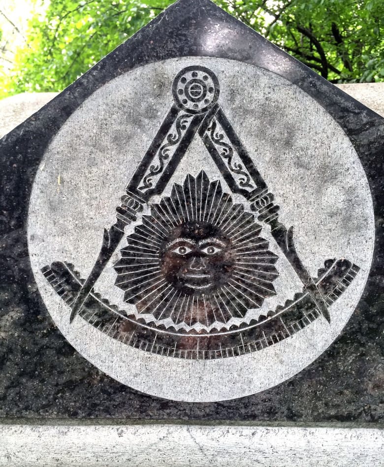 Stone tombstone with a symbol of a sun.