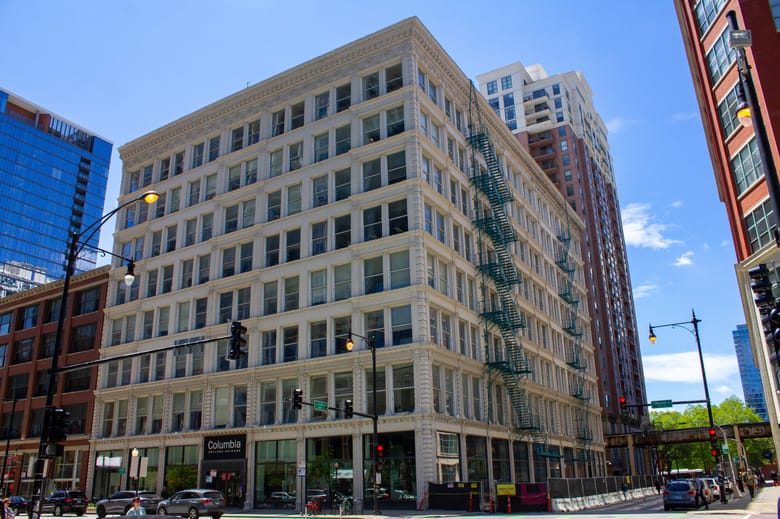 Image of a 3 story gray stone building.