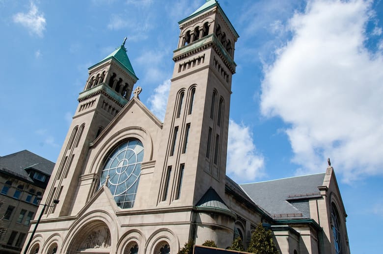 Stone church, featuring Gothic Revival architecture and intricate stained glass windows.