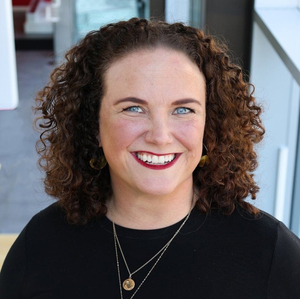 Caucasian woman with curly brown hair in a black top