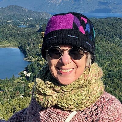 Lady with a color hat and round glasses smiling