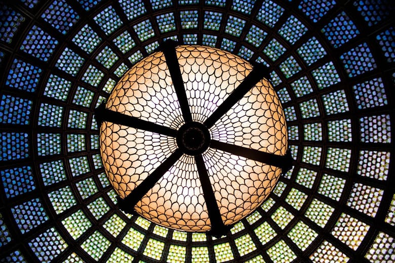 Looking up at large stained glass domed ceiling