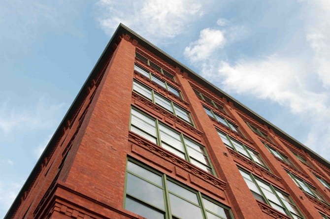 Image of a red brick building taken from below with a blue sky above