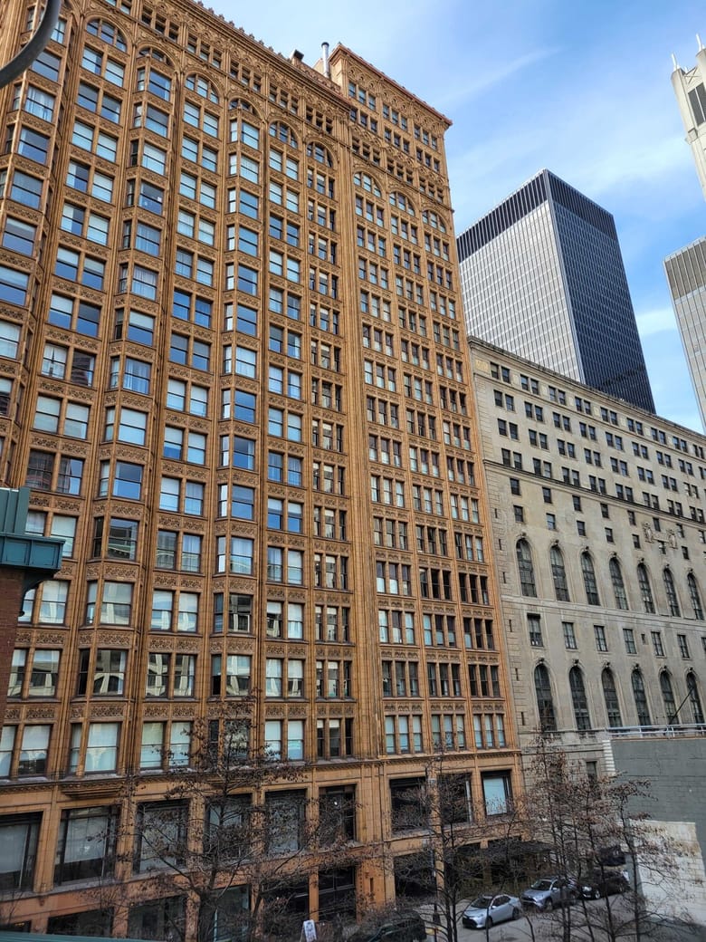 Looking up at reddish beige building