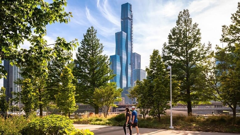 View of tall glass building through a park with trees