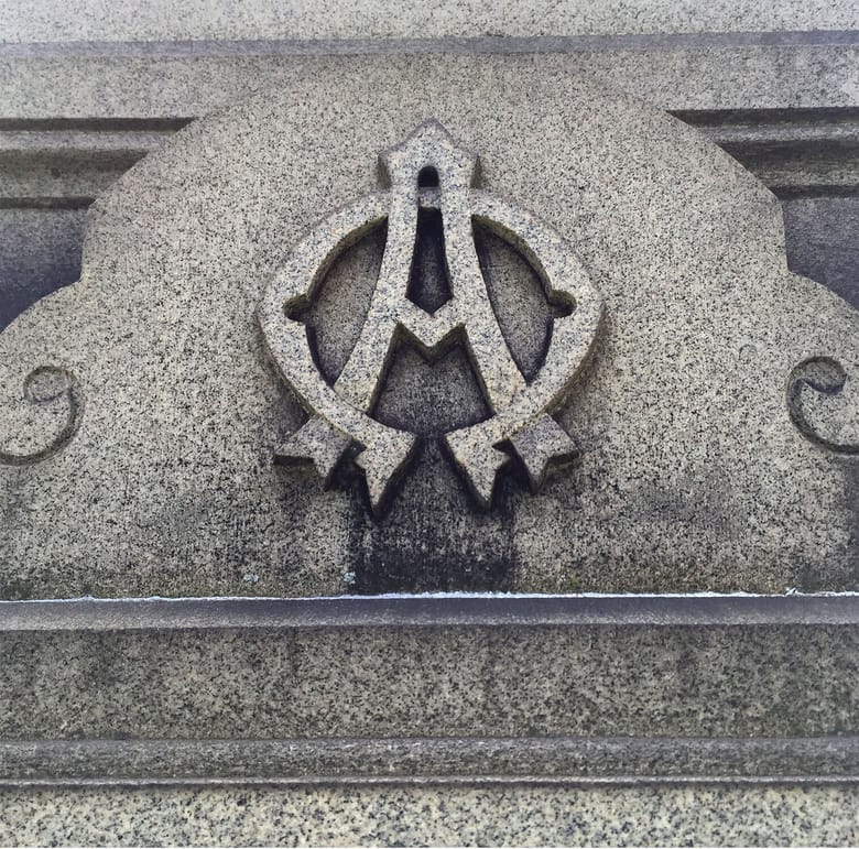 Stone tombstone with a symbol of an "A" on it.