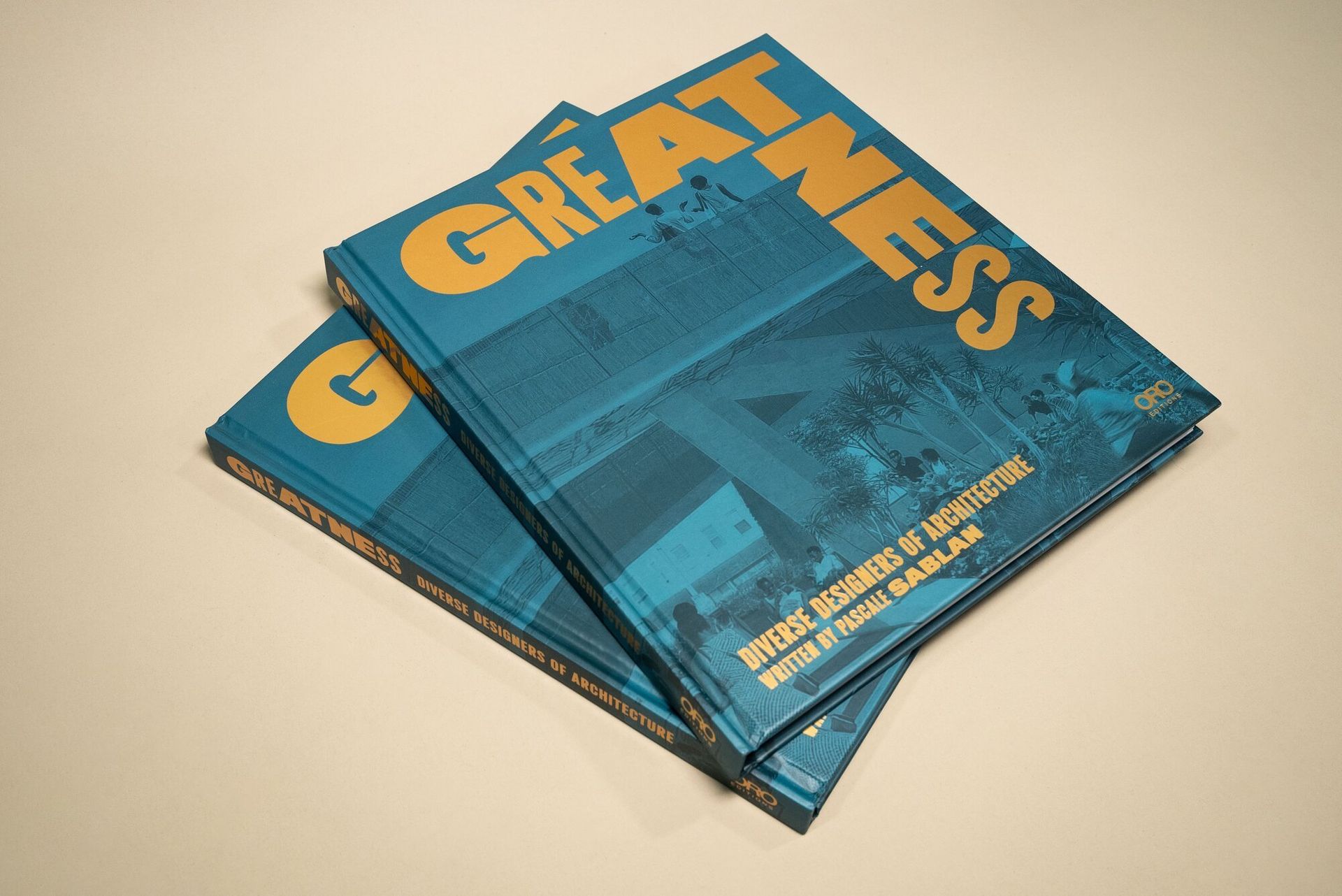 book with a blue duo tone effect on the cover and bright yellow all caps title that reads "Greatness"