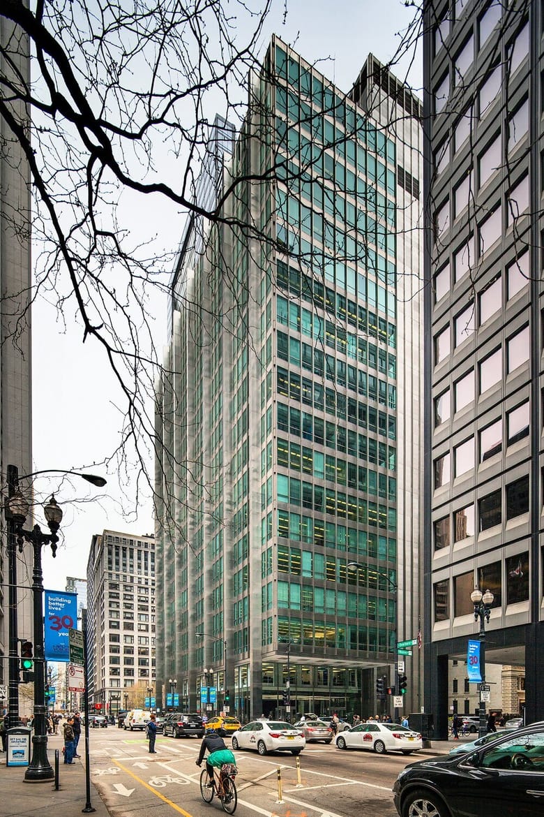 Exterior shot of a building from the corner showing the walls covered in blue-green glass