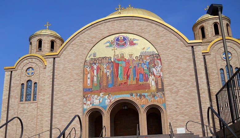 An orange brick building with a colorful mosaic on the front.