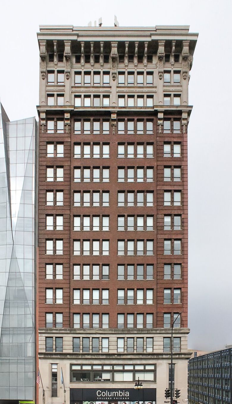 Image of a tall red brick building with windows.