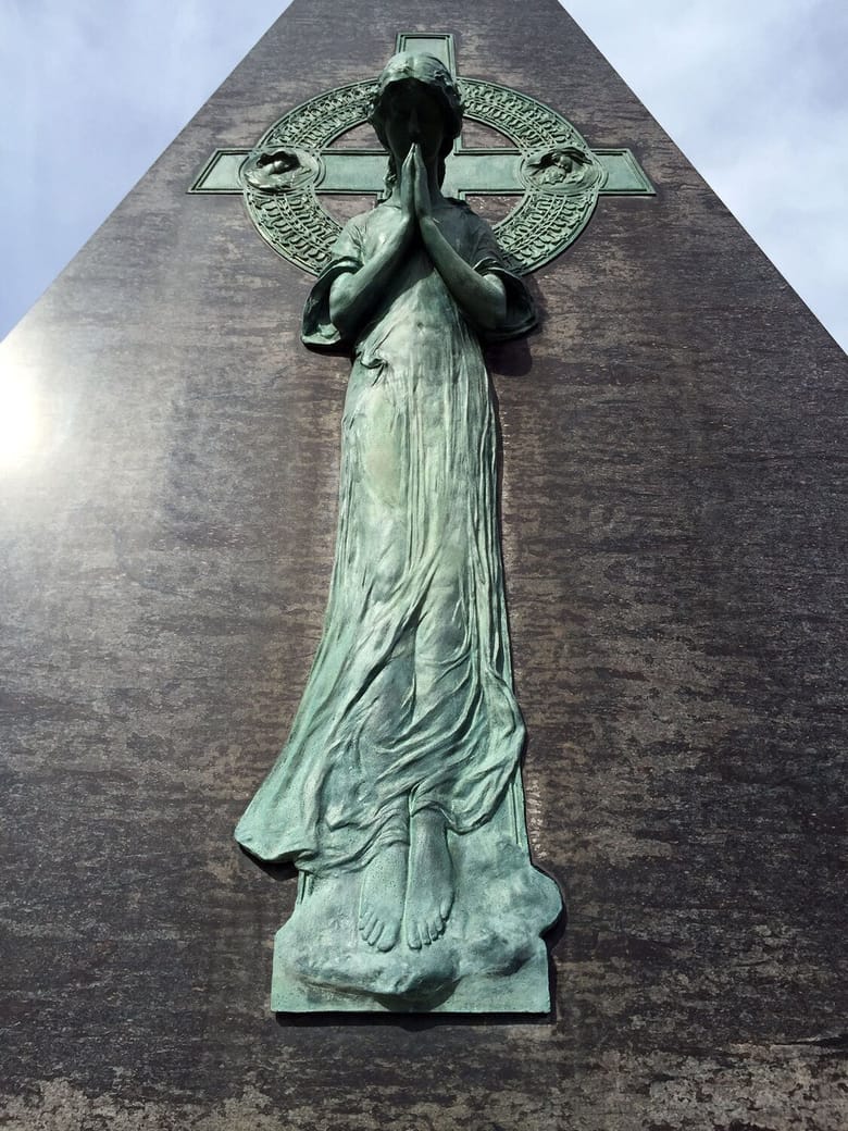 green bronze statue in a cemetary