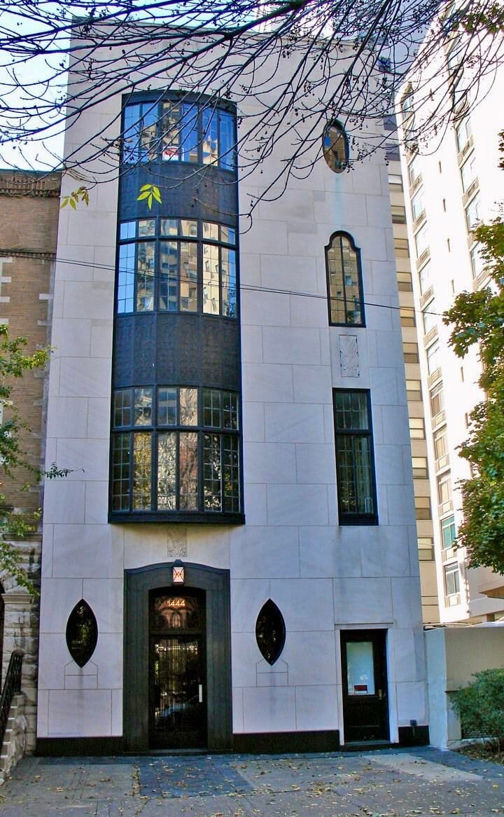 Four story white stone house with tall windows. 