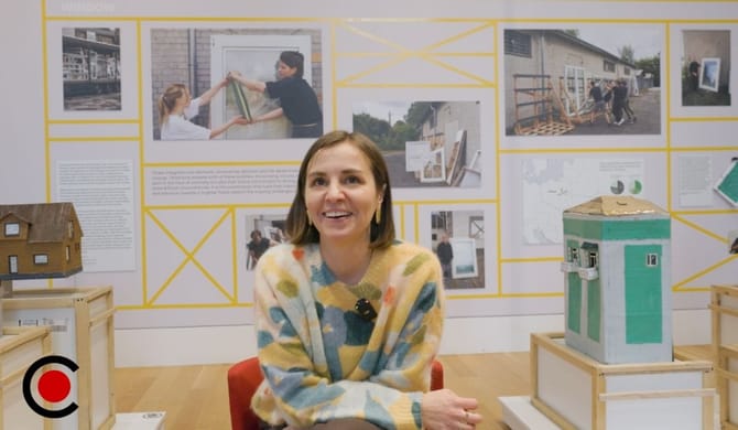 Image of a woman with short brown hair in a colorful sweater smiling.